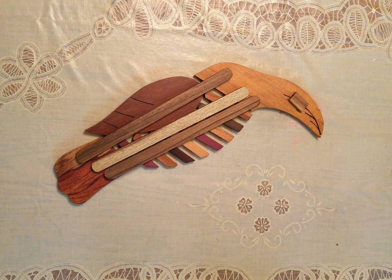K&ouml;nnte beinhalten: Eine Holzskulptur eines Vogels, gefertigt aus verschiedenen Braunt&ouml;nen von Holz. Der Vogel ist in Flugposition dargestellt, mit ausgebreiteten Fl&uuml;geln.