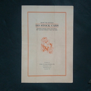 May include: A vintage instruction booklet for building HO gauge stock cars. The cover features a cartoon illustration of a train conductor with a red and white cap and a red and white striped shirt. The text on the cover reads "How to Build HO Stock Cars" and "Instructions for Building HO Gauge Stock Car No. 6504". The booklet was published by WM. K. Walthers, Inc. in Milwaukee, Wisconsin.