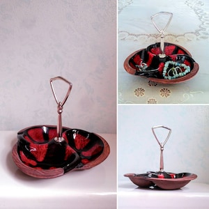 May include: A three-sectioned wooden serving tray with a red and black glaze. The tray has a silver handle and is perfect for serving snacks or appetizers.