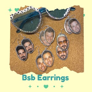 May include: A collection of Backstreet Boys-themed earrings and sunglasses. The earrings feature oval-shaped images of the band members with silver trim. The sunglasses are blue with the words "BACKSTREET BOYS" spelled out on the frames.