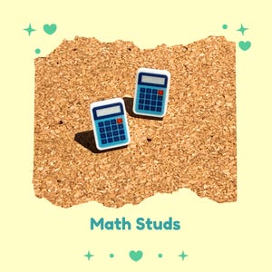May include: Two blue and white calculator-shaped stud earrings with red accents. The earrings are displayed on a textured, brown surface. The text "Math Studs" is below the earrings.