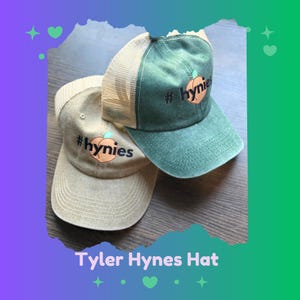 May include: Two baseball caps, one tan and one green, are displayed. Both caps feature a peach graphic with the text "#hynies". The green cap has a mesh back. The text "Tyler Hynes Hat" is at the bottom.