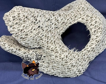May include: A light gray, three-dimensional animal head base constructed from a dense, open-cell foam mesh material. The structure features a prominent snout and a large circular eye opening. A logo with the text Kitty Up! Fursuits and Mascots is visible.