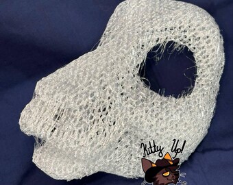 May include: A white, semi-transparent, three-dimensional mesh mask base with a snout and a large circular eye opening. The structure is composed of a dense, web-like filament pattern. A logo with the text Kitty Up! Fursuits and Mascots is visible.