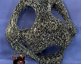 May include: A black and metallic gold 3D printed animal mask with a mesh-like structure, featuring large eye openings and a snout area. A logo with the text Kitty Up! Fursuits and Mascots is visible in the lower left corner of the image.