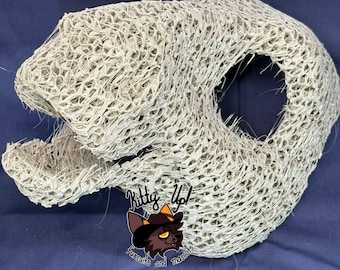 May include: A beige, open-mesh, three-dimensional animal head base for a fursuit, featuring a hollow interior, a defined snout, and an open mouth. A logo with the text Kitty Up! Fursuits and mascots is visible on the lower front section.