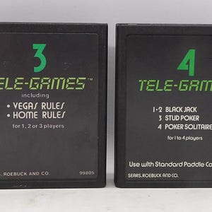 May include: Two black Tele-Games cartridges. One features the number 3 and includes Vegas and Home Rules for 1, 2, or 3 players. The other has the number 4 and lists Black Jack, Stud Poker, and Poker Solitaire for 1 to 4 players.