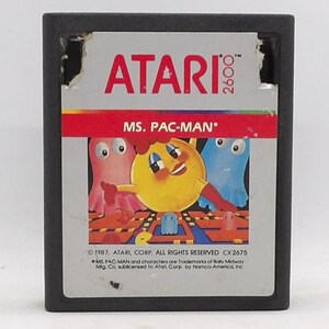 May include: Atari 2600 video game cartridge for Ms. Pac-Man. The label features the game's title in red, with a yellow Pac-Man character and two ghosts. The cartridge is black.