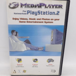 May include: A Media Player game case for PlayStation 2. The cover features the game's logo, a couple watching TV, and icons for watching videos, listening to music, and viewing digital images. The case is in a black plastic case.