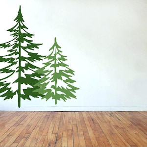May include: Two green stylized pine trees on a white wall. The larger tree is on the left and the smaller tree is on the right.