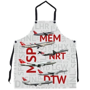 May include: A white apron with a red and white Northwest Airlines logo and a pattern of airport codes, including MSP, MEM, NRT, and DTW. The apron features a white background with red text and a red and white logo.