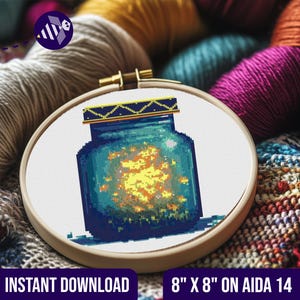 Può includere: Uno schema di punto croce di un barattolo di vetro blu pieno di lucciole gialle luminose. Lo schema è su una tela Aida 14 di 20,3 cm x 20,3 cm. Lo schema include versioni a colori e in bianco e nero.