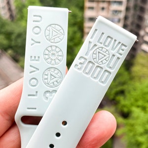 May include: Two light gray watch bands with the text "I Love You 3000" and an Iron Man symbol.