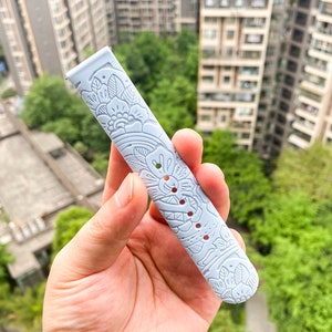 May include: A light blue watch band with a white floral pattern.