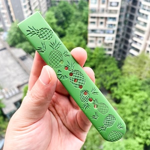 May include: A green watch strap with a pineapple pattern. The strap is made of a soft, flexible material and has a textured surface.