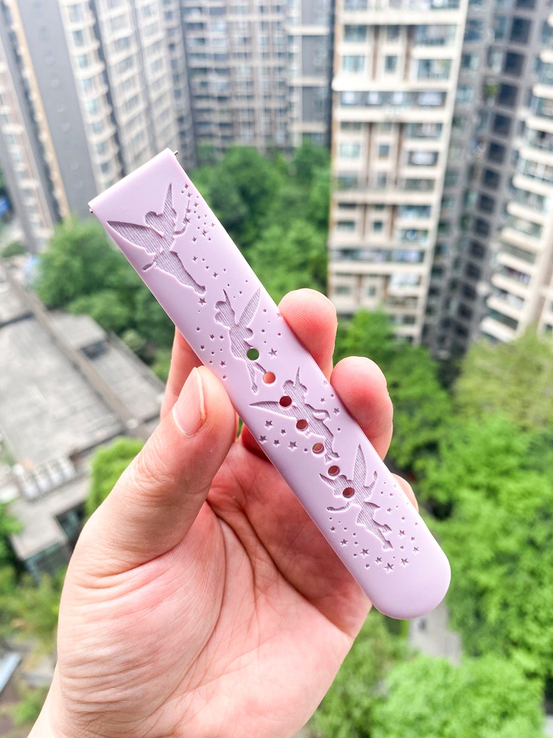 May include: A lavender silicone watch band with a cut-out design of Tinkerbell and stars.