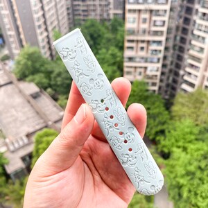 May include: A light blue silicone watch strap with a repeating pattern of Mickey Mouse and Minnie Mouse characters.
