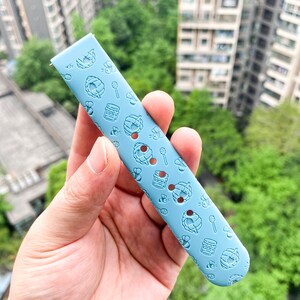 May include: A light blue silicone watch band with a repeating pattern of honeycombs, bees, and honey jars.