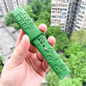 May include: Green silicone watch strap with the words "STAR WARS" embossed on the top and various Star Wars characters embossed on the bottom.