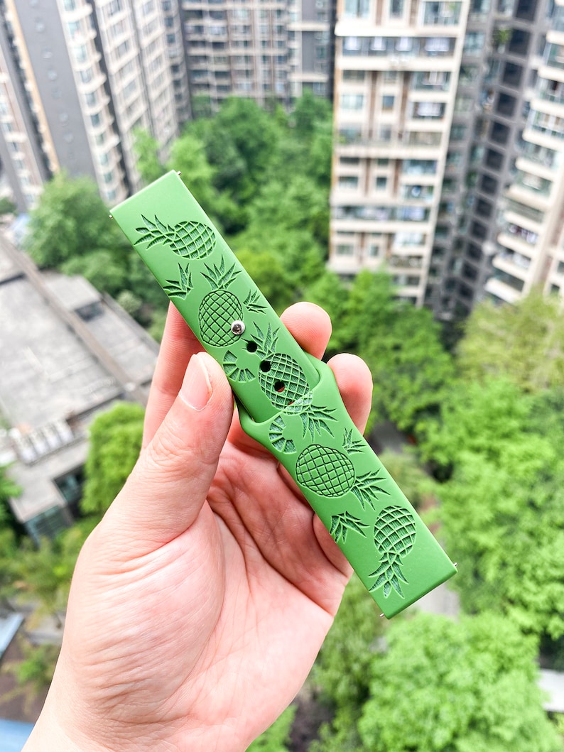 May include: Green silicone watch strap with a pineapple design.