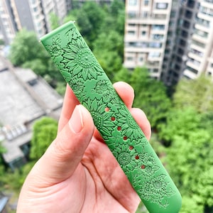 May include: Green watch band with a sunflower pattern.