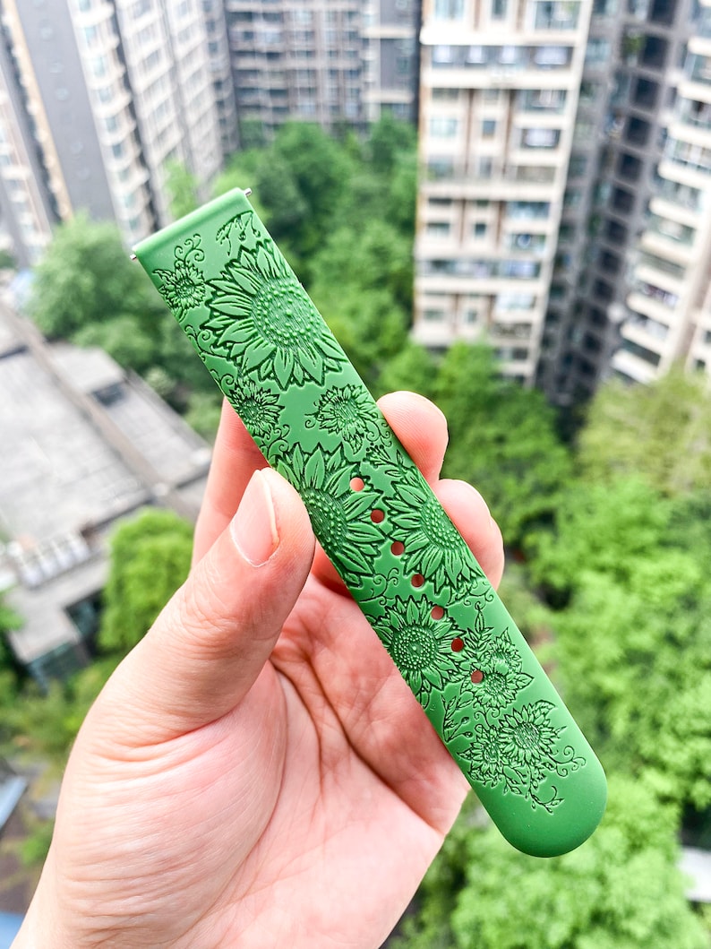 May include: Green watch band with a sunflower pattern.