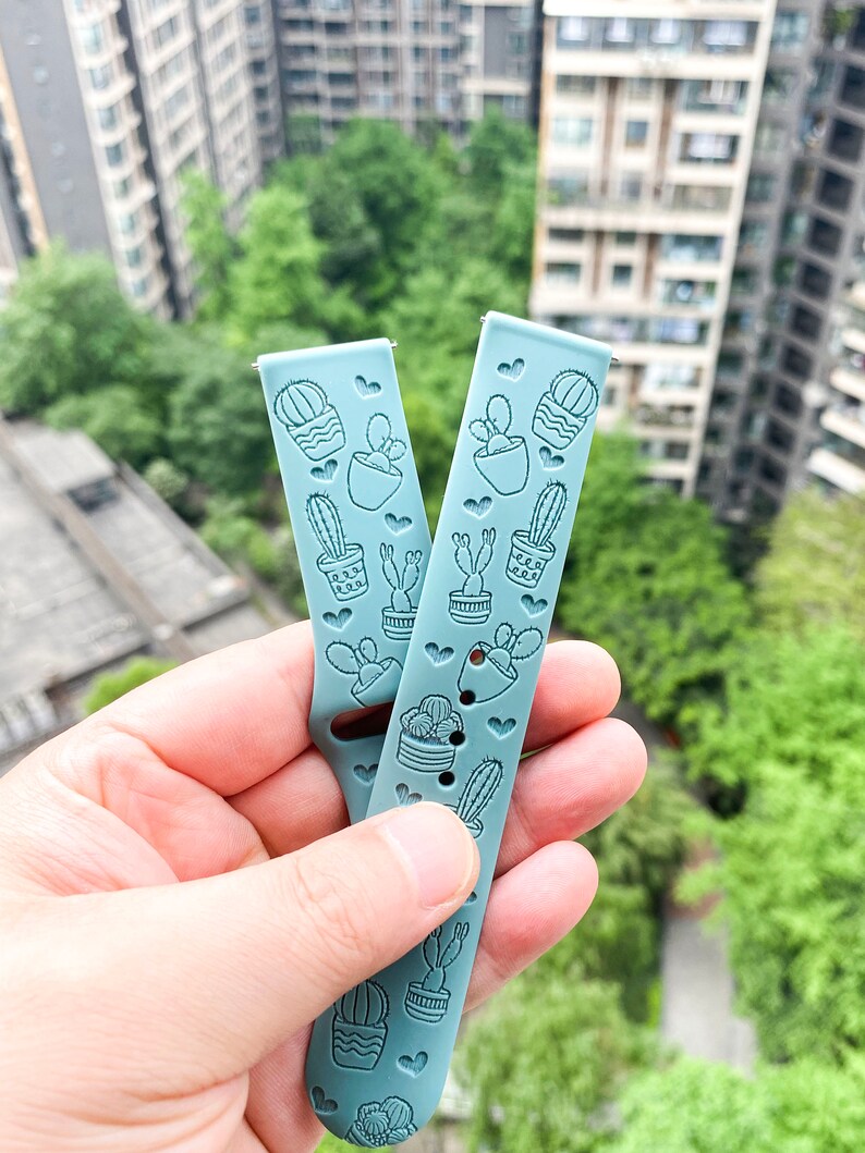 Puede incluir: Dos correas de reloj de silicona azul claro con estampado de cactus. Las correas tienen un patr&oacute;n de coraz&oacute;n y est&aacute;n dise&ntilde;adas para un reloj inteligente.