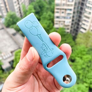 May include: A light blue silicone watch band with a Winnie the Pooh design. Pooh is holding balloons and the band has a silver metal buckle.