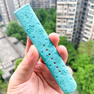 May include: A light blue silicone watch band with a Mickey Mouse and Halloween themed design. The band features various Mickey Mouse characters, ghosts, and other Halloween icons.