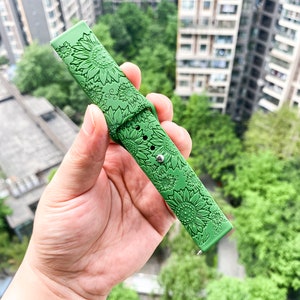 May include: Green silicone watch band with a sunflower design.