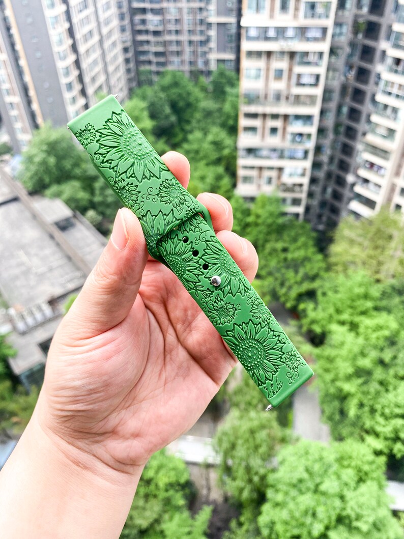 May include: Green silicone watch band with a sunflower design.