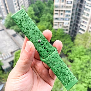 May include: Green silicone watch band with a sunflower pattern.