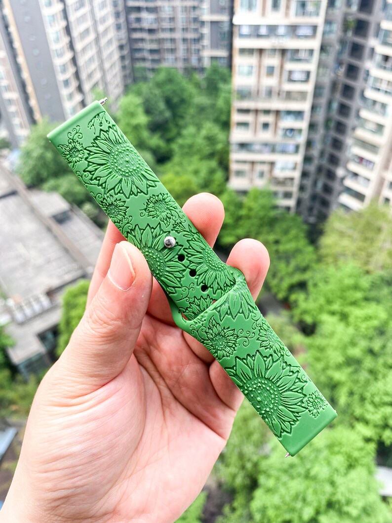 May include: Green silicone watch band with a sunflower pattern.