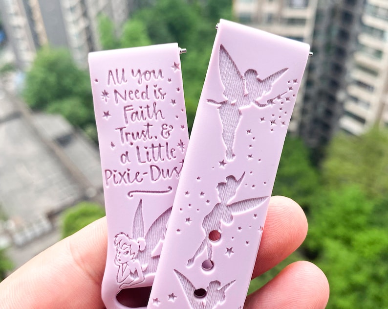 May include: A pink silicone watch band with a Tinkerbell design and the text "All you Need is Faith Trust & a Little Pixie-Dust".