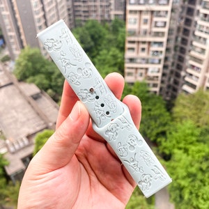 May include: A light blue silicone watch strap with a white Mickey Mouse design.