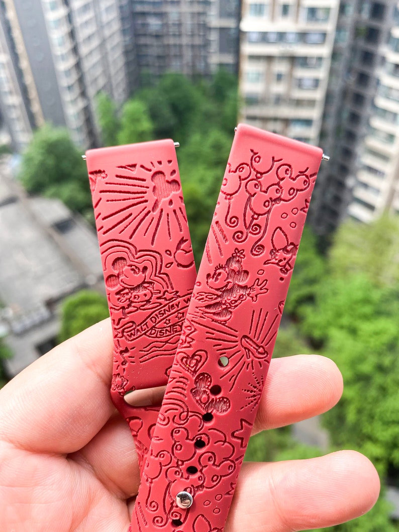 Puede incluir: Dos correas de reloj de silicona roja con un dise&ntilde;o de Mickey Mouse blanco y negro. Las correas presentan una variedad de ilustraciones de Mickey Mouse, incluyendo Mickey Mouse con globos, Mickey Mouse con una estrella y Mickey Mouse con una nube. Las correas tambi&eacute;n presentan el texto "Walt Disney World" y "Disney".
