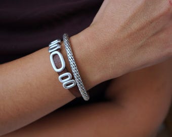 Bruine leren wikkelarmband: zilveren schuivers, moderne stapelsieraden