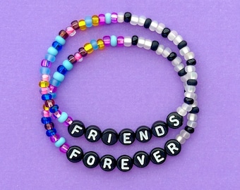 May include: A friendship bracelet made with colorful beads and black letter beads spelling "FRIENDS FOREVER".