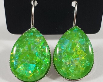 May include: A pair of silver teardrop earrings with green iridescent glass stones.