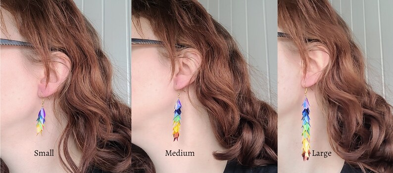K&ouml;nnte beinhalten: Drei Paar Regenbogen-Ohrringe in verschiedenen Gr&ouml;&szlig;en: klein, mittel und gro&szlig;. Die Ohrringe bestehen aus schimmernden, &uuml;berlappenden Schuppen.