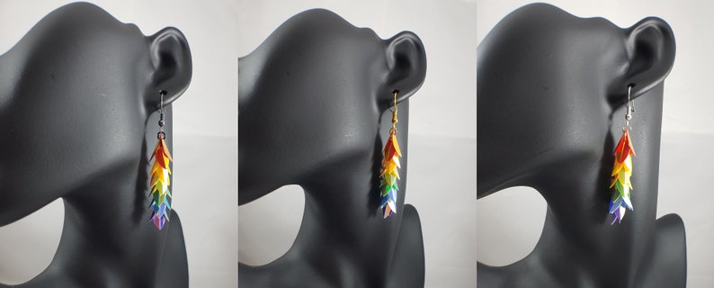 May include: Rainbow colored dangle earrings with a silver hook. The earrings are made of multiple small, layered, triangular shapes.