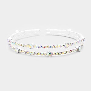 May include: A silver double-row bangle bracelet with iridescent rhinestones.