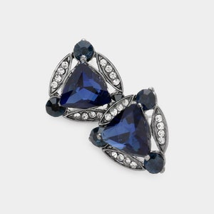 May include: A pair of silver tone earrings with a triangular blue gemstone surrounded by smaller clear rhinestones.