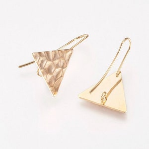 May include: A pair of gold triangle earrings with a textured finish. One earring has a smooth surface.