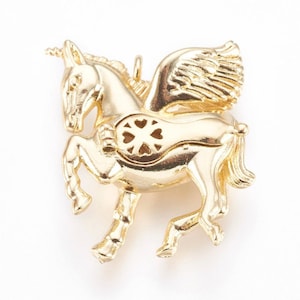 May include: A gold-colored pendant in the shape of a winged unicorn. The unicorn has a horn, wings, and a decorative heart-shaped design on its side. The pendant is likely made of metal and is designed to be worn as jewelry.