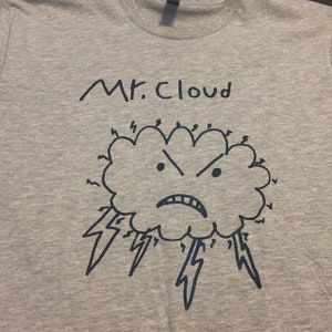 May include: A heather gray t-shirt featuring a hand-drawn illustration of an angry cloud with lightning bolts. The text "Mr. Cloud" is above the cloud design in dark blue.