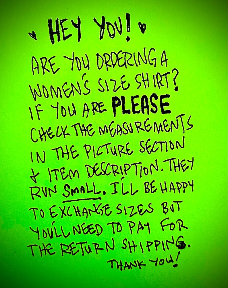 May include: A green handwritten note with the text "HEY YOU! ARE YOU ORDERING A WOMEN'S SIZE SHIRT? IF YOU ARE PLEASE CHECK THE MEASUREMENTS IN THE PICTURE SECTION + ITEM DESCRIPTION. THEY RUN SMALL. ILL BE HAPPY TO EXCHANGE SIZES BUT YOU'LL NEED TO PAY FOR THE RETURN SHIPPING. THANK YOU!"