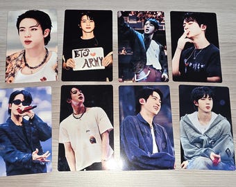 May include: Eight rectangular photo cards featuring a person with dark hair in various outfits and settings. One card shows the person holding a white sign with the text BTS ARMY. The images capture different poses, including singing and casual portraits.