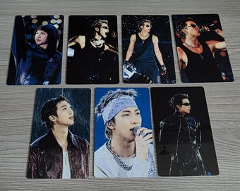 May include: Seven rectangular photo cards featuring a person in various poses. The cards showcase the person in different outfits, including a hooded jacket, tank tops, and a leather jacket. The images have a dark, moody aesthetic.