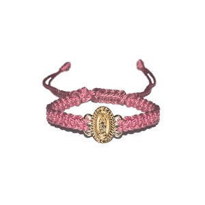 May include: A pink braided bracelet with a gold oval charm featuring a religious image.